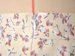 Close-up of the invisible zipper and high waist detail on the floral chiffon skirt