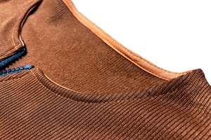 Macro shot of dark brown ribbed knit collar featuring detailed black zipper stitching