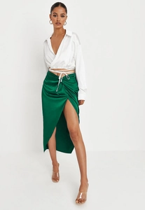 Detail of emerald green satin midi skirt with a high slit and smooth silky texture finish