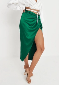 Detailed close-up of emerald green satin midi skirt with side slit and drawstring waist