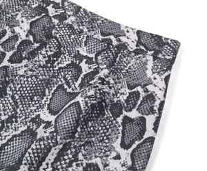 Vue macro détaillée du motif serpent gris et des coutures fines sur la jupe à taille haute
