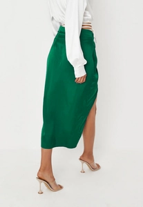 Close-up of emerald green satin midi skirt showing side slit and fabric texture