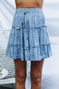 Detail of tiered blue floral mini skirt showing elastic waist and drawstring with metal tips