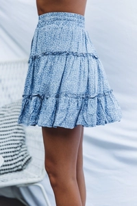 Detail of blue floral tiered mini skirt featuring elastic high waist and ruffled chiffon fabric