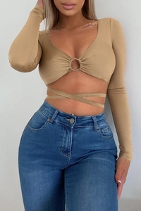 Detail of khaki long sleeve crop top featuring V-neck silver buckle and waist wrap ties