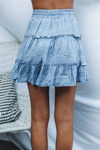 Detail view of the elastic waist and triple-layered ruffle hem on blue floral mini skirt
