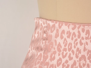 Vue détaillée du tissu satiné léopard rose jacquard et texture de couture latérale