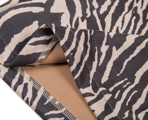 Vue macro de la couture plate sur une mini-jupe en faux daim à imprimé zébré de qualité