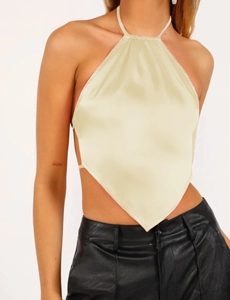 Detail of champagne satin halter top with open back and diamond hem texture