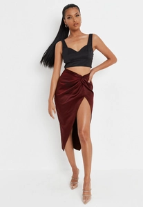 Detail of elegant wine red satin midi skirt featuring front knot and high side slit design