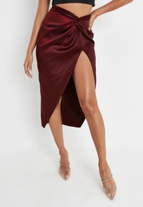 Detail shot of wine red satin midi skirt featuring twist waist and high slit design