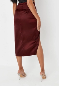 Detail view of wine red satin midi skirt featuring a high side slit and silky texture