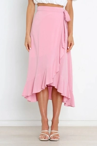 Detail of pink wrap skirt featuring a self-tie waist and asymmetric ruffled hemline