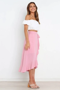 Detail of pink wrap skirt with side bow tie and asymmetrical ruffled hem for summer