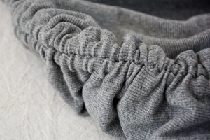 Detailed macro view of the grey ribbed knit fabric and adjustable drawstring waist structure