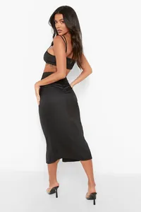 Detail of elegant black satin midi skirt and matching backless bralette on a fashion model