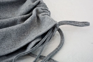 Detail of grey ribbed knit fabric with adjustable drawstring and side ruching effects