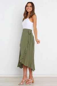 Detail showing an olive green wrap skirt with an irregular ruffle hem and waist tie detail