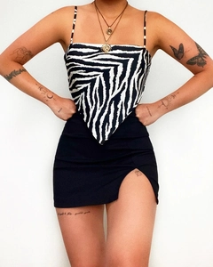 Detail view of zebra print camisole top paired with a black side slit mini skirt