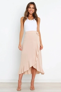 Detail of light apricot wrap skirt with layered ruffles and elegant waist tie design