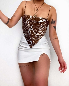 Detail of marble print scarf top with skinny straps and white mini skirt with side slit