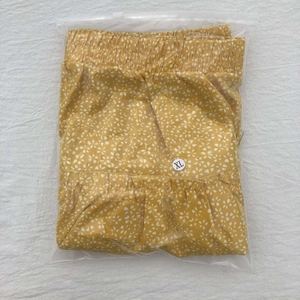 Flat lay of yellow floral ruffled mini skirt packaged in a clear zipper polybag