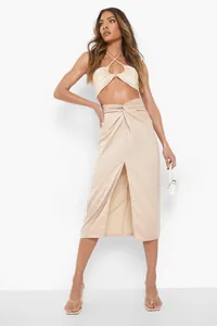 Detail view of champagne satin midi skirt with elegant waist knot and high leg slit