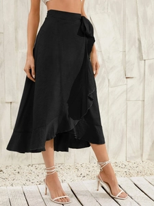 Detail of high-waisted black wrap skirt with ruffle hem and side tie in textured fabric
