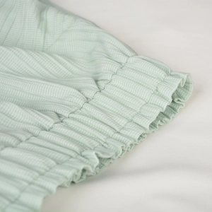 Close-up of mint green ribbed mini skirt featuring elastic smocked high waist detail