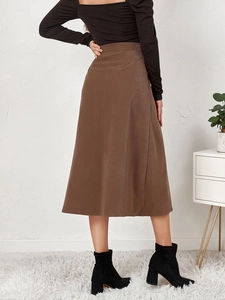 Detail of high waist brown corduroy midi skirt with fine striped texture and A-line silhouette