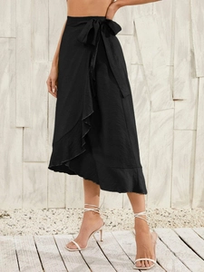 Detail of black wrap midi skirt showing high waist tie-up bow and ruffle hemline