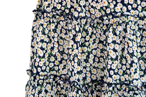 Detail of high-waisted floral skirt with navy daisy print and tiered ruffle layers