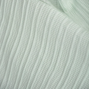 Detailed macro shot of mint green ruffle fabric with wavy textured seersucker pattern