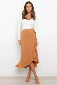 Detail view of caramel wrap skirt with adjustable waist tie and asymmetrical ruffle hem