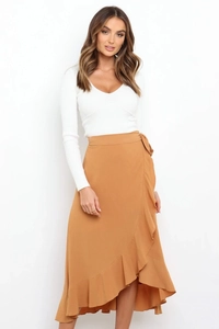 Detail of the caramel wrap skirt with ruffled edges and asymmetrical hemline design