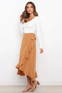 Detail of caramel wrap skirt with asymmetric ruffled hem and waist tie closure