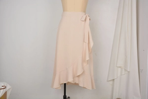 Detail of the ruffle hem and side tie on an apricot chiffon wrap skirt for women