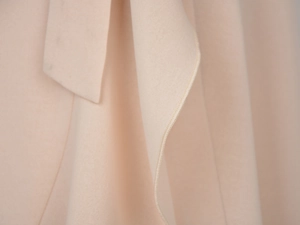 Close-up of beige chiffon skirt fabric showing high-quality stitching and smooth texture