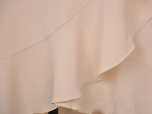 Detailed view of the ruffle hem and fine stitching on a flowy beige chiffon skirt