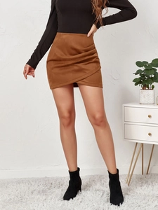 Detail view of brown faux suede skirt with pleated draping and asymmetrical wrap design