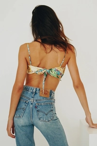 Detail of printed halter top with back ribbon tie and classic denim jeans on a model