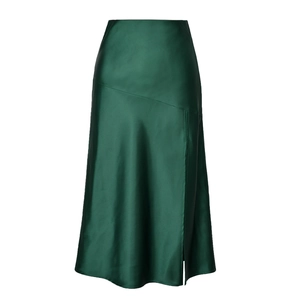 Detail of dark green satin skirt showing silk gloss, diagonal seam, and high side slit