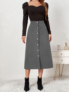 Close-up of high-waist dark grey corduroy skirt with single-breasted metal buttons