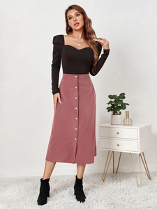 Close-up of high-waist corduroy skirt with single-breasted buttons and pink velvet texture