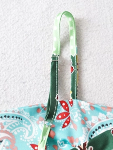 Detail of adjustable polka dot straps and blue paisley fabric on a sexy camisole top