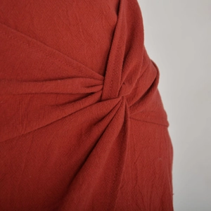 Gros plan sur le nœud et la texture en lin de la mini-jupe taille haute terre cuite