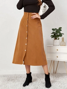 Close-up of brown corduroy high-waisted skirt with silver buttons and vertical texture
