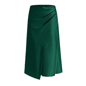 Détail d'une jupe en satin vert foncé avec plis élégants à la taille et fente latérale