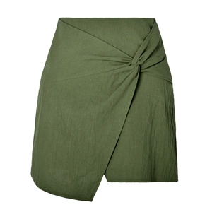 Détail de la mini-jupe en coton-lin vert olive avec nœud à la taille et ourlet asymétrique