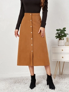 Detail of high waist corduroy skirt showing vertical texture and single-breasted buttons